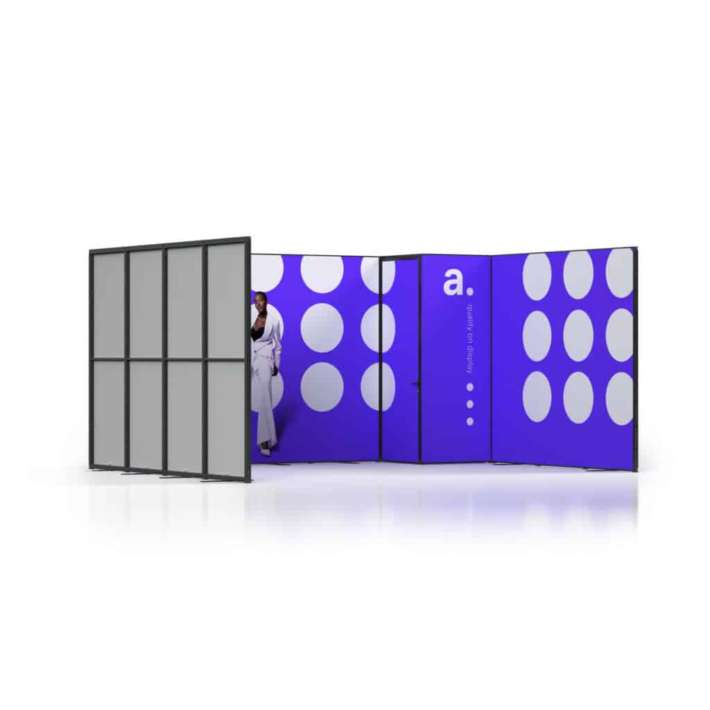 Beursstand Een modern privacy hokje met blauwe en witte stippen panelen en de letter a. op één muur. Een persoon in witte kleding staat gedeeltelijk zichtbaar achter het open tussenschot.