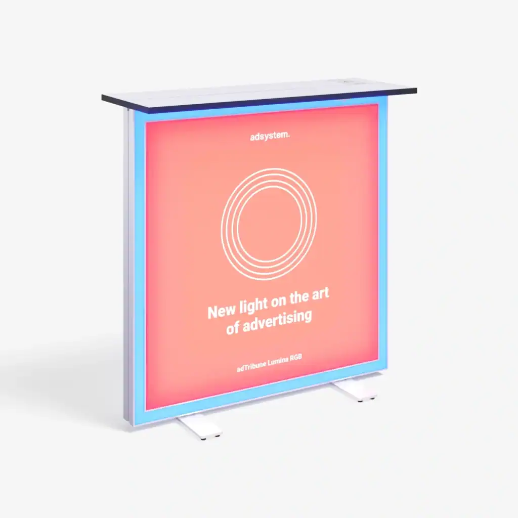 Beursstand Een rechthoekige, verlichte reclamedisplay met een roze voorkant, witte tekst en cirkelvormige afbeelding en een blauwe oplichtende rand. De tekst luidt: Nieuw licht op de kunst van reclame. mTribune Lumina RGB.